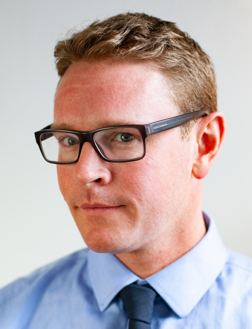 Justin Smith, career and entrepreneurship coach, wearing glasses and a blue shirt